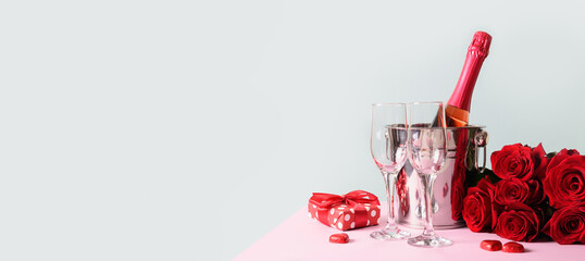 Valentine's day greeting card with gift and red sparkling wine on blue. Banner with copy space.