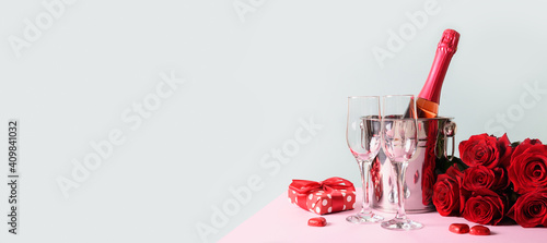 Valentine's day greeting card with gift and red sparkling wine on blue. Banner with copy space. photo