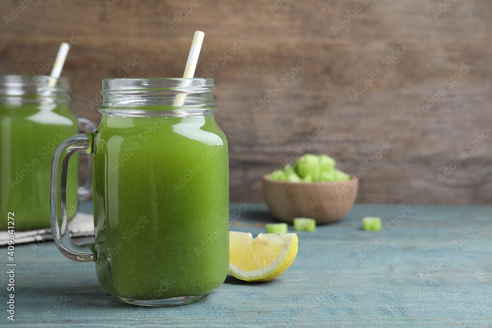 Fresh celery juice and lemon slice on blue wooden table, closeup. Space for text Fresh celery juice and lemon slice on blue wooden table, closeup. Space for text