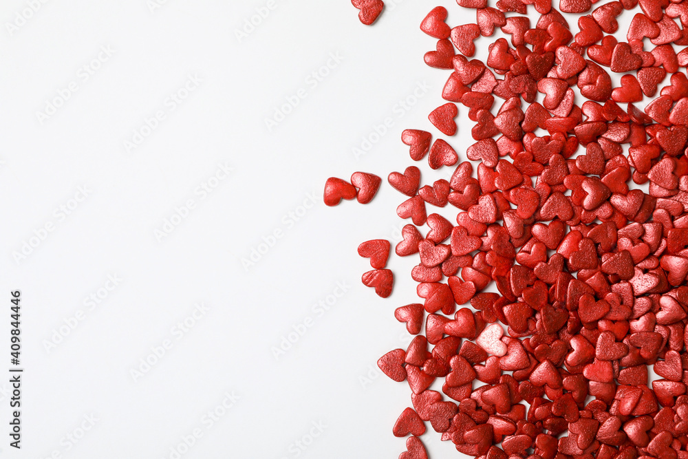 Bright heart shaped sprinkles on white background, flat lay. Space for text Bright heart shaped sprinkles on white background, flat lay. Space for text