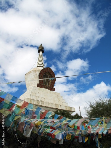 Pagoda surrounded by Tibetan talisman flags on a cloudy day.