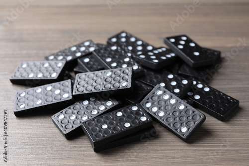 Pile of black domino tiles on wooden table