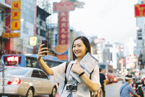 Photography Traveler, travel young woman or girl use smart phone camera taking photo,selfie or shooting video call at china town,city downtown