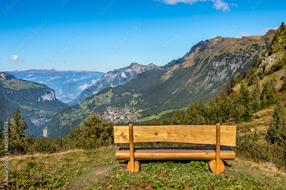 Wooden  bench at hiking trail from Grindelwald to Wengen at Jungfrau region, Switzerland.