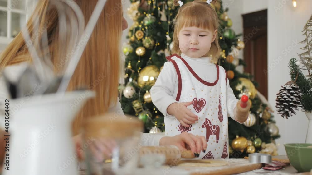 Family of mom and daughter prepare Christmas cookies on the kitchen Family of mom and daughter prepare Christmas cookies on the kitchen