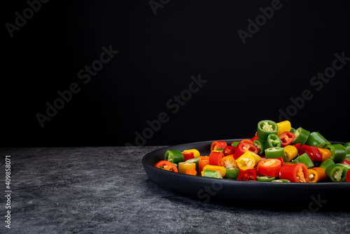 Pepper slices on black dull plate