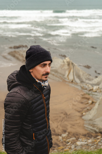 Man in the sea looking at camera in mountain clothes