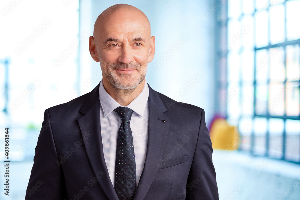 Smiling middle aged businessman standing in the office