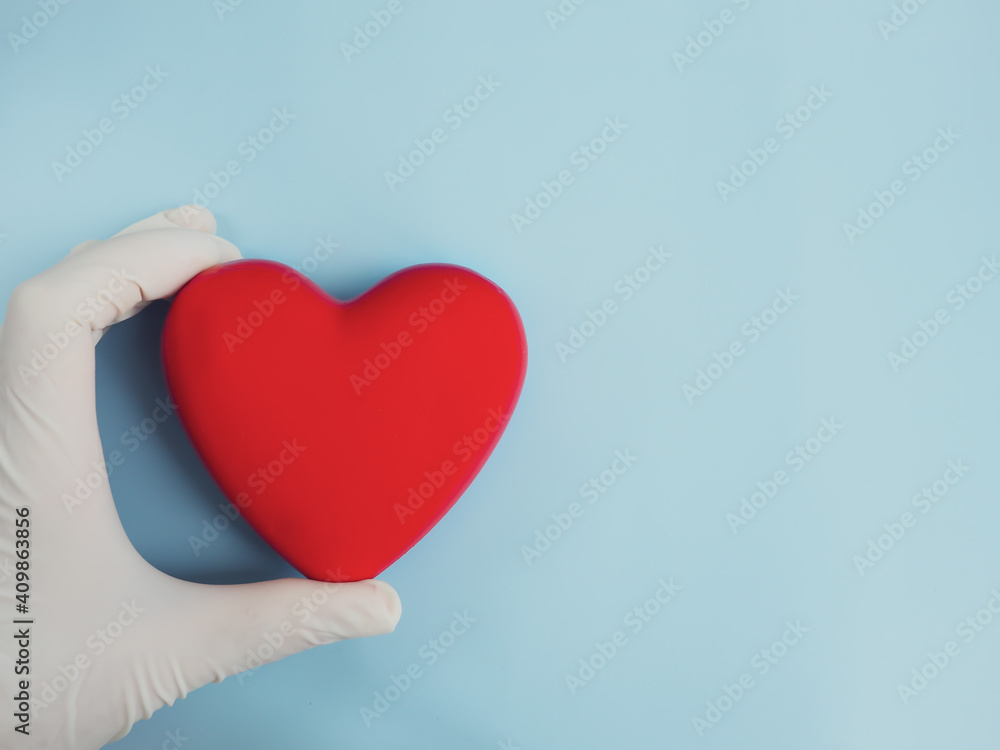 Doctor's hands in medical gloves with red heart, health insurance, organ donation, charity during the covid-19 coronavirus pandemic, life saving, heart health, World Heart Day, Saving Lives. Doctor's hands in medical gloves with red heart, health insurance, organ donation, charity during the covid-19 coronavirus pandemic, life saving, heart health, World Heart Day, Saving Lives.