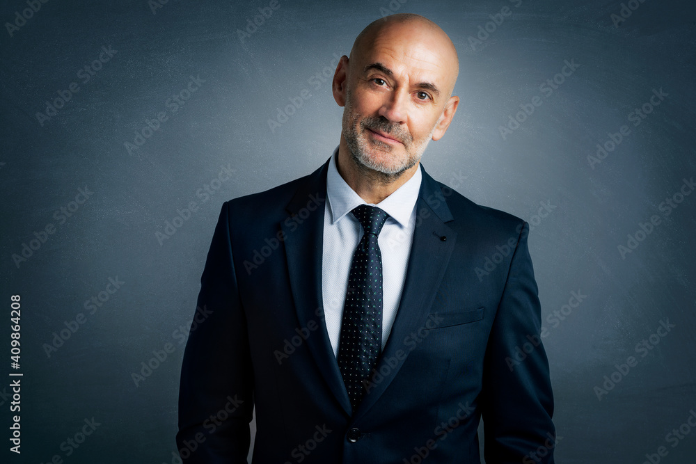 Middle aged businessman portrait while standing at isolated grey background Middle aged businessman portrait while standing at isolated grey background