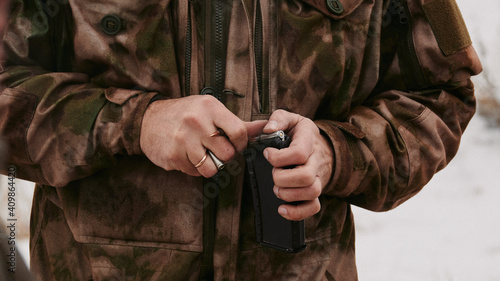 A shooter with a gold ring on his finger (married or engaged) loads 5.45x39mm rounds