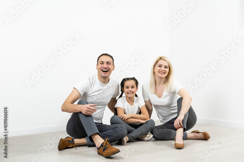 happy young family sitting on floor with home concept