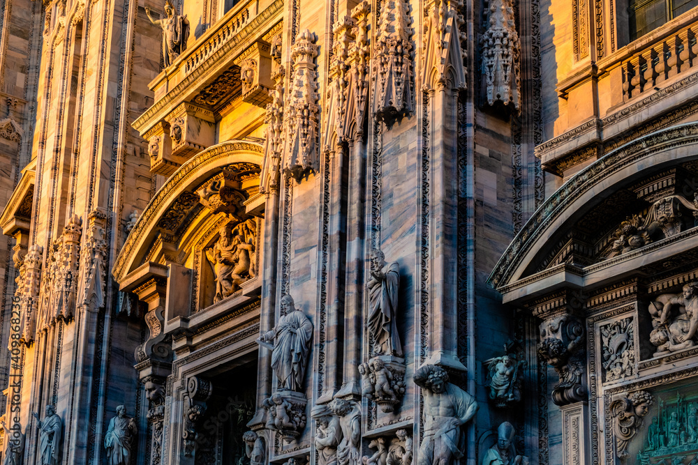 Statues on Milan Duomo facade in sunset light