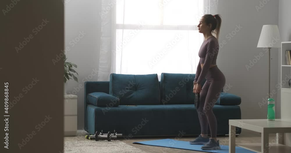 sexy lady with ponytail is doing squats with weight in hands, training buttocks and legs muscles, home fitness exercises sexy lady with ponytail is doing squats with weight in hands, training buttocks and legs muscles, home fitness exercises