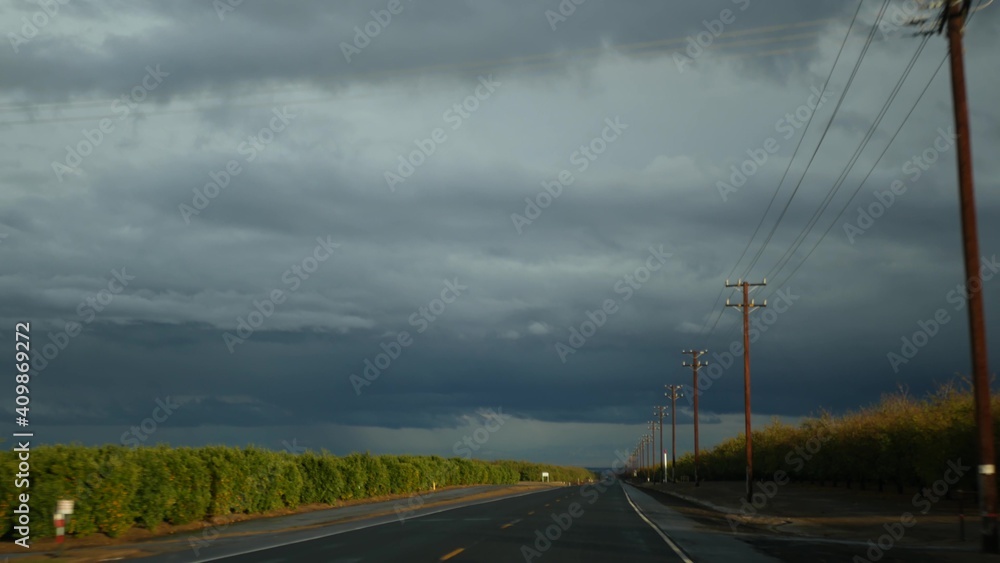 Driving auto, road trip in California, USA, view from car. Hitchhiking traveling in United States. Highway, mountains and cloudy dramatic sky before rain storm. American scenic byway. Passenger POV.