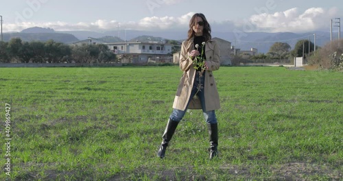 Ragazza con cappotto marrone e stivali neri in campagna photo