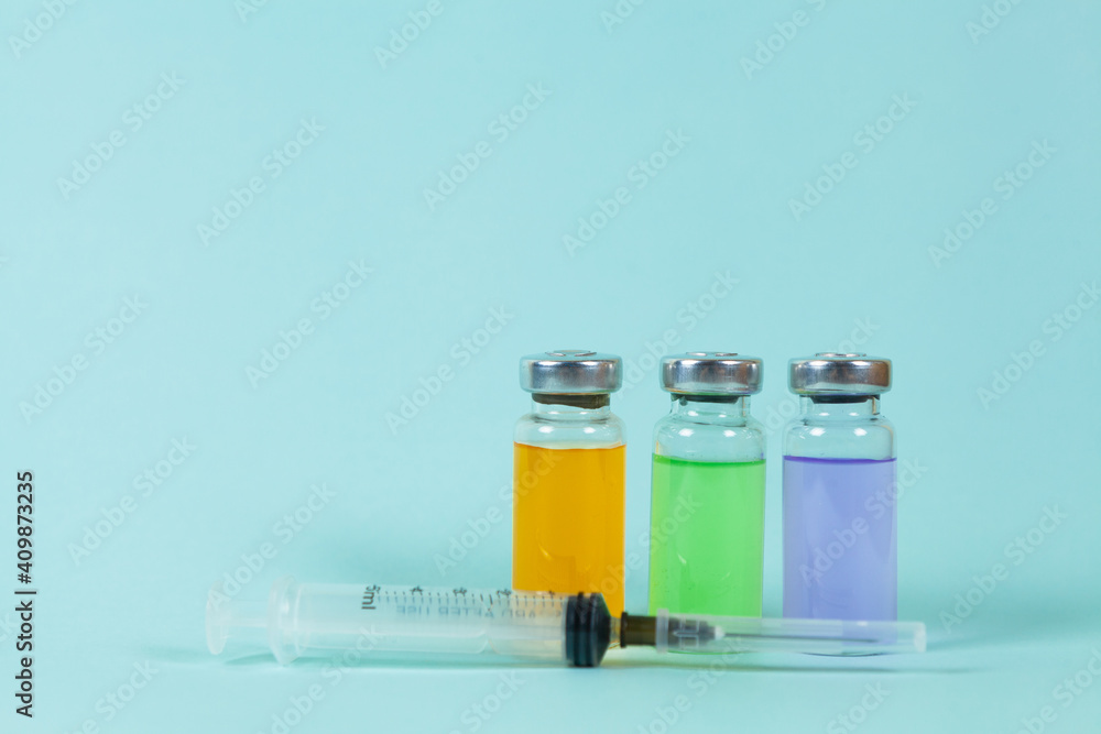 Covid-19 Recorded vaccine bottle with liquid and and syringe on a blue background. Place for text Covid-19 Recorded vaccine bottle with liquid and and syringe on a blue background. Place for text