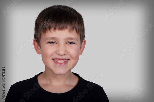 portrait of a laughing boy on a gray background
