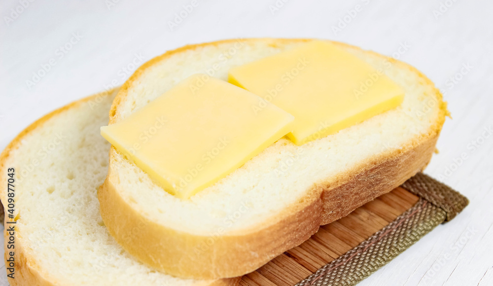 White bread with sliced hard cheese. A grilled cheese sandwich.