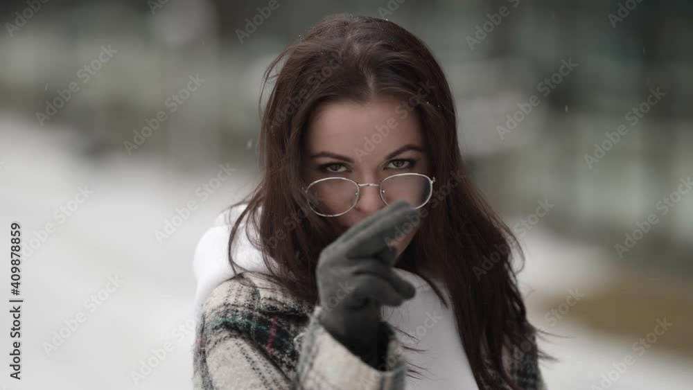 young woman is intimidating jokingly, looking at camera, outdoors portrait at winter day young woman is intimidating jokingly, looking at camera, outdoors portrait at winter day