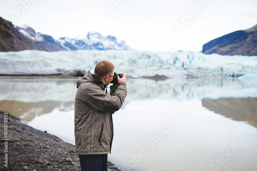 photographer making picture of lake and mountains