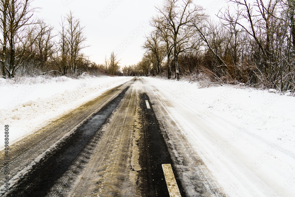 Dividing lines, road markings under snow and ice are visible on the roadway. Dividing lines, road markings under snow and ice are visible on the roadway.