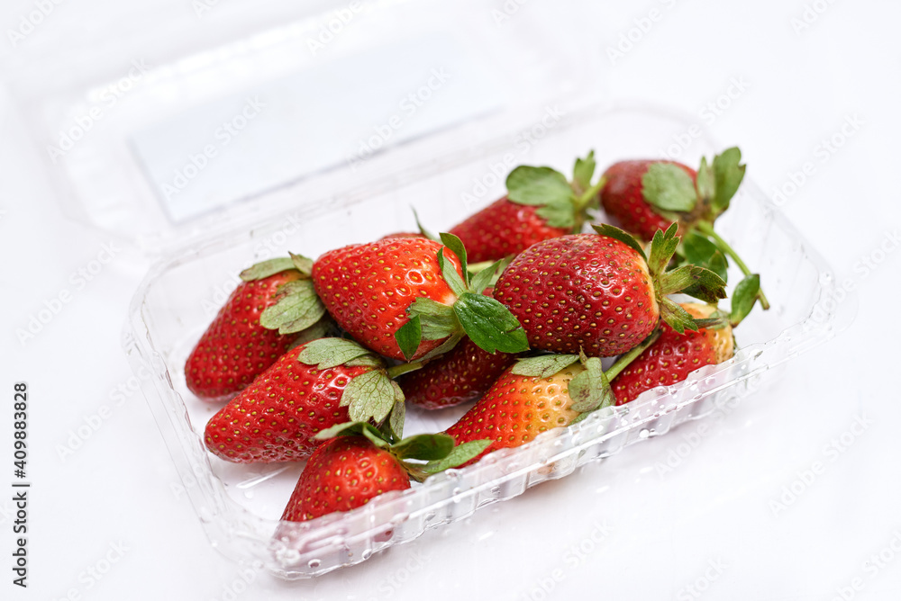 fresh strawberries in a container on a white background fresh strawberries in a container on a white background