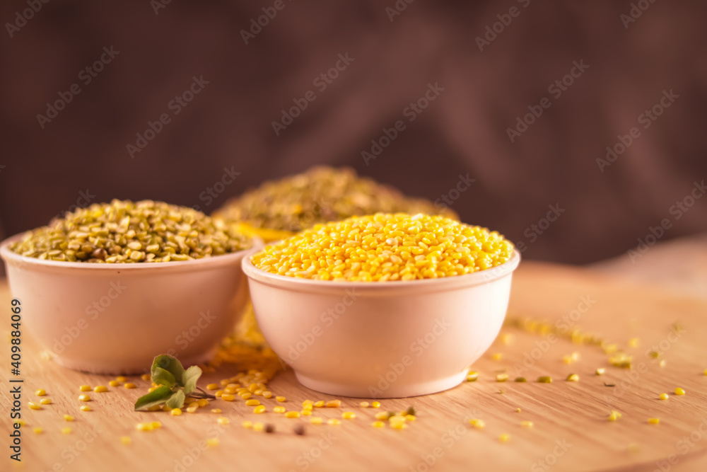 Broken Mung Lentils (Moong Dal) spilled on agriculture background,green moong dal in bowl,Peeled Green Beans. Broken Mung Lentils (Moong Dal) spilled on agriculture background,green moong dal in bowl,Peeled Green Beans.
