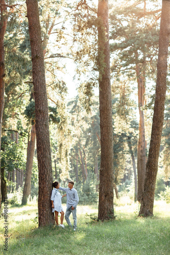 Cheerful young woman and man are hugging outdoors in summer park. Dating and romantic vacation. couple in love gently looking at each other on sunny day. Love and relationships between young people