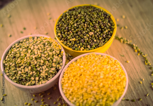 Green and yellow moong mung dal lentil pulse bean on black background, yellow Mung dal and green Moong bean rotation on wooden table, high protein moong dal photo