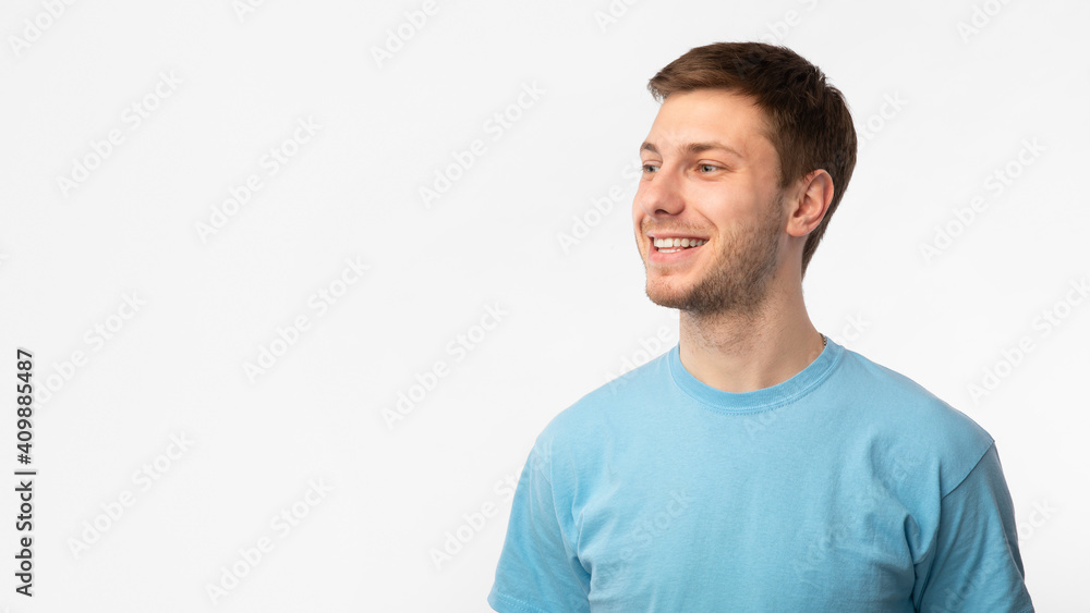 Fototapeta premium Smiling confident guy looking at copy space on white background