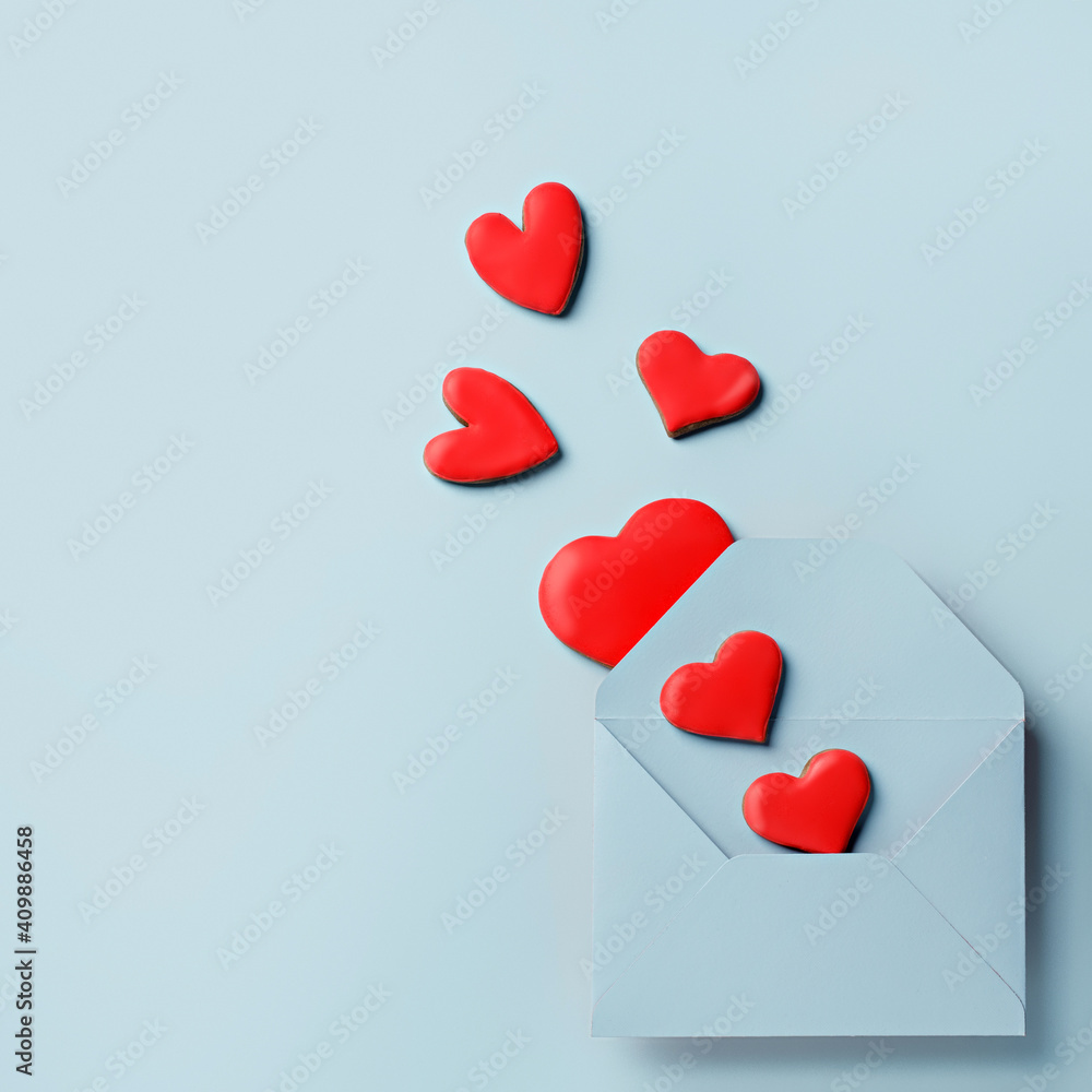 Love layout made with red hearts coming out of blue envelope on pastel background. Creative Valentine's Day, wedding, dating, spring or love concept. Flat lay.