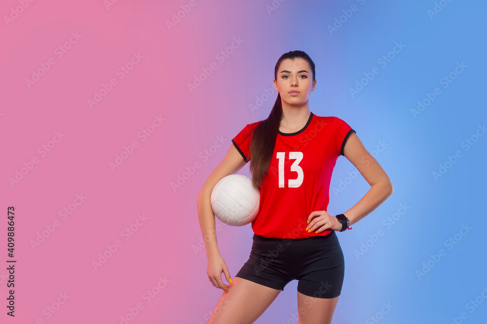Volleyball girl hold and kick ball on neon background. Player doing sport workout at home. Sport and recreation concept Volleyball girl hold and kick ball on neon background. Player doing sport workout at home. Sport and recreation concept