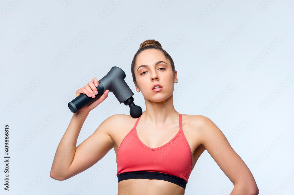 Electric massager gun in hand massages your muscles. Sport recovery concept Electric massager gun in hand massages your muscles. Sport recovery concept