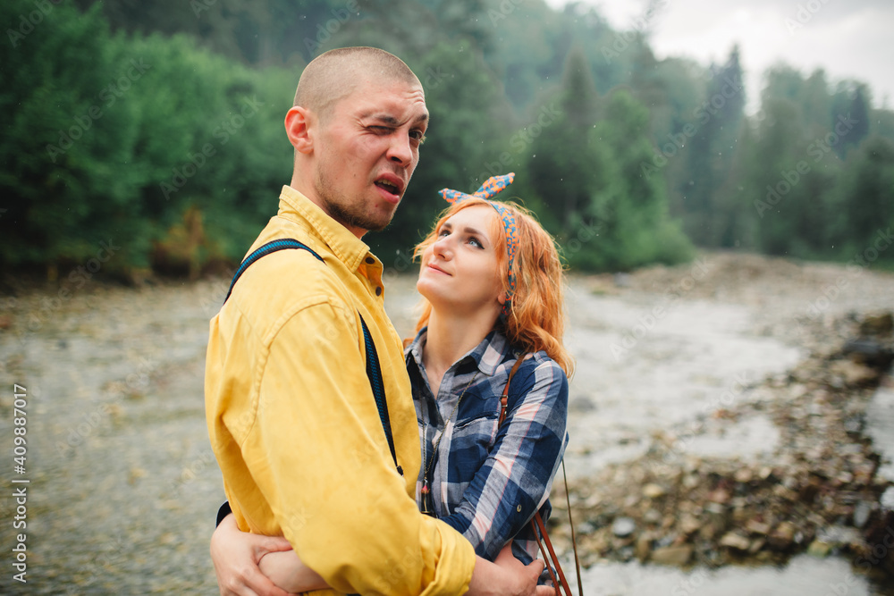 Playful happy handsome couple having while walking in woods. tourists in the mountains. Adventure in nature concept. Playful happy handsome couple having while walking in woods. tourists in the mountains. Adventure in nature concept.