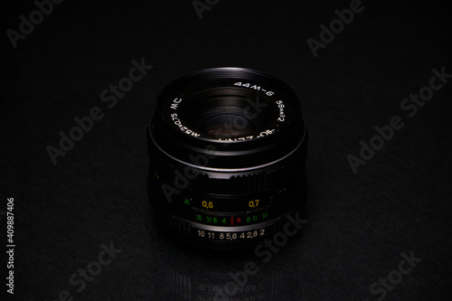 Lens from the USSR on a black background and glass