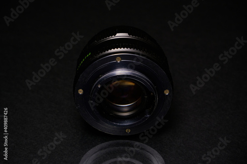 Lens from the USSR on a black background and glass