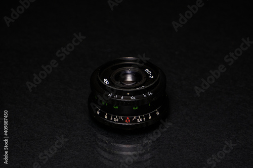 Lens from the USSR on a black background and glass