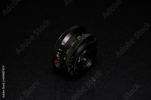 Lens from the USSR on a black background and glass