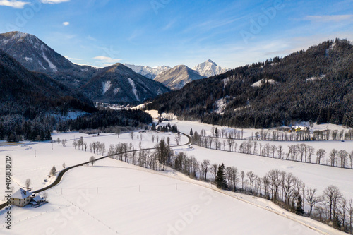 Aerial winter landscape with mountain village and forest covered in snow. Zgornje Jezersko, Slovenia. photo