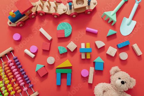 Canvas Print Kids toys, teddy, wooden colorful blocks and train on red color background