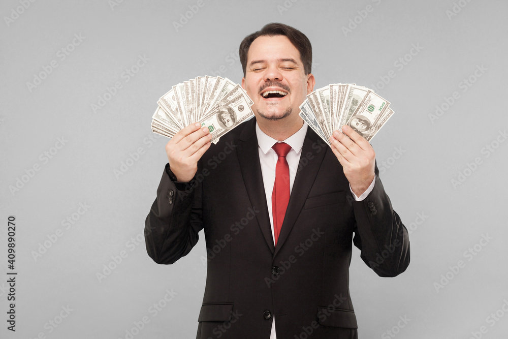© khosrork - Man honestly earned a lot of money. Indoor, studio shot, isolated on gray background