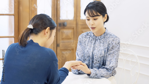 会話する女性　ビューティアドバイザー　占い師　手相占い