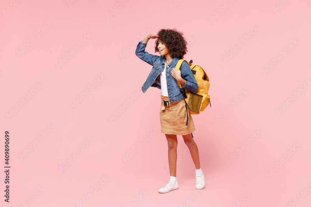 Full length happy little african american kid school girl 12-13 year old in casual clothes, backpack hand at forehead look far away distance isolated on pink background. Childhood education concept Full length happy little african american kid school girl 12-13 year old in casual clothes, backpack hand at forehead look far away distance isolated on pink background. Childhood education concept