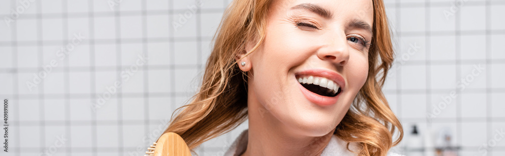 happy woman smiling and brushing hair in bathroom, banner happy woman smiling and brushing hair in bathroom, banner