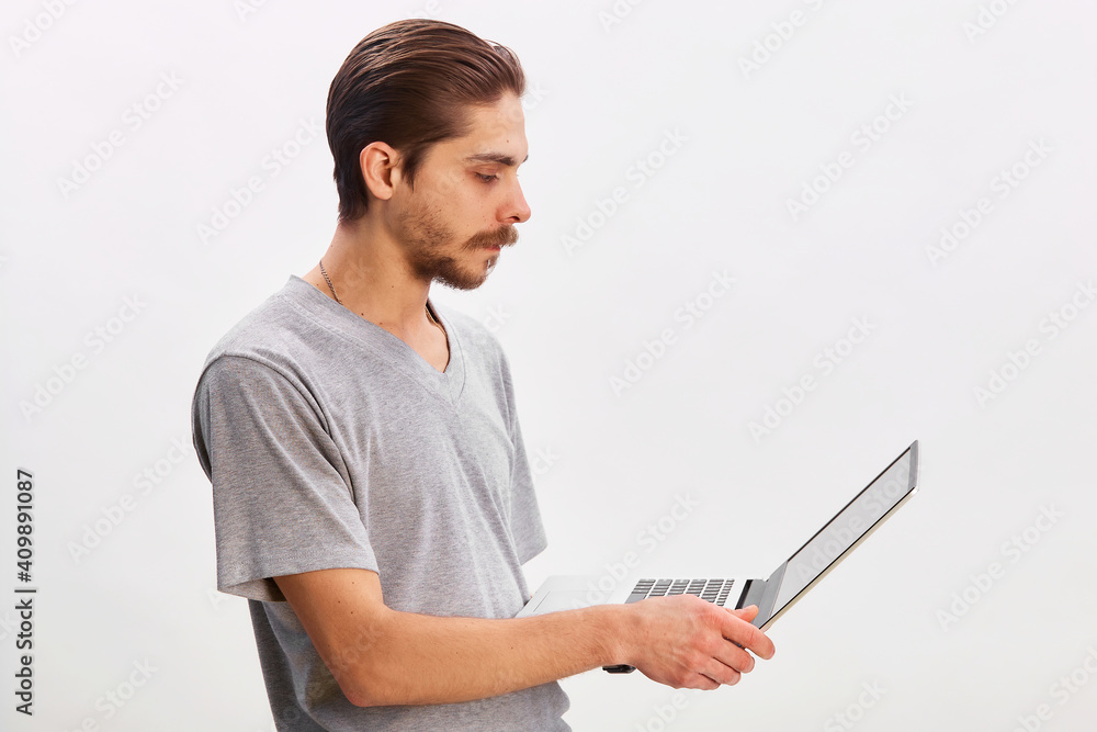 Portrait of a cheerful man using laptop computer over gray background Portrait of a cheerful man using laptop computer over gray background