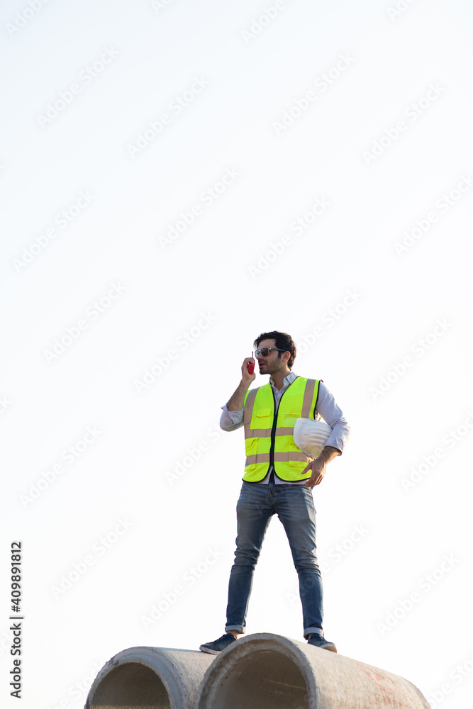 Middle Eastern Civil engineer operate worker on radio to control working at construction site. Middle Eastern Civil engineer operate worker on radio to control working at construction site.