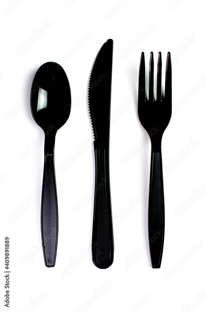 Black plastic cutlery knife fork spoon isolated on white background low highlight. For kitchen restaurant and table set up. concern to plastic conservative recycle items and one time use utensils Black plastic cutlery knife fork spoon isolated on white background low highlight. For kitchen restaurant and table set up. concern to plastic conservative recycle items and one time use utensils