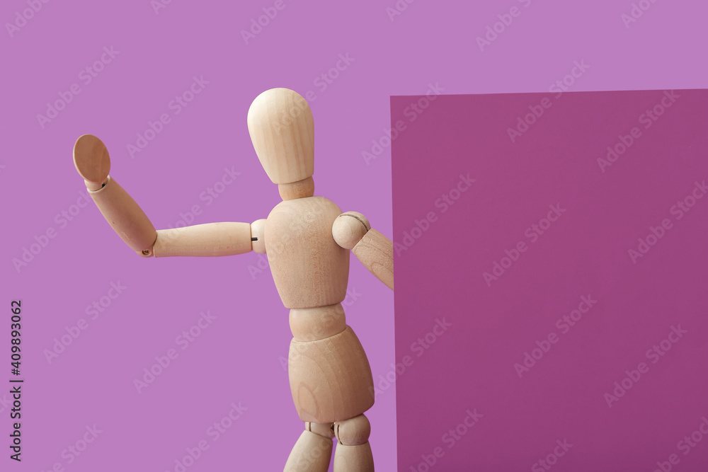 Wooden mannequin with blank poster on color background Wooden mannequin with blank poster on color background
