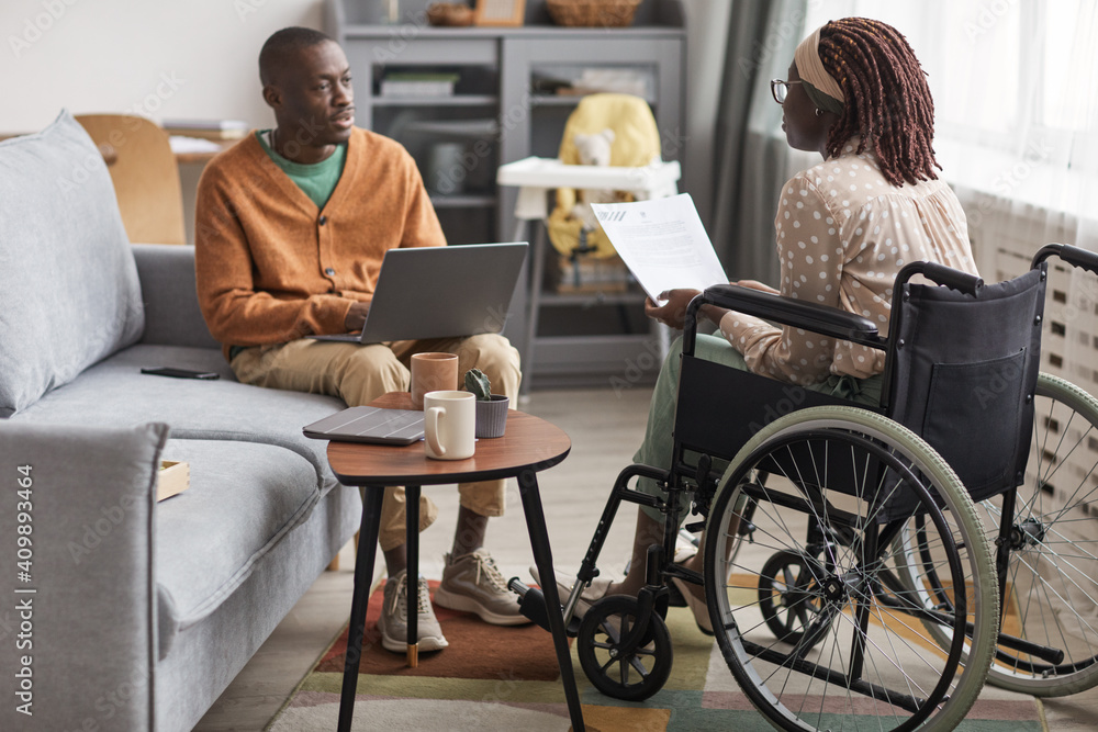 Full length portrait of African-American couple with handicapped woman working from home together - obrazy, fototapety, plakaty 